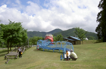 ケヤキの森公園芝生広場で遊ぶ家族連れの写真