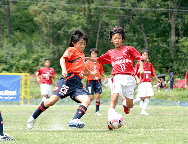 汗を流してサッカーをする子どもたちの写